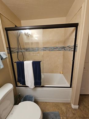 Glendale house for rent - A white toilet sits in a bathroom next to a bathtub.