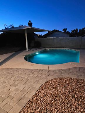 Glendale house for rent - A pool surrounded by a stone patio and a gravel area.