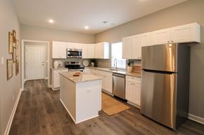 Little Rock house for rent - A modern kitchen with white cabinets and a stainless steel refrigerator.