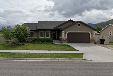 Payson house for rent - A house with a grey garage door and a brown roof.