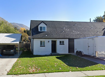 Springville house for rent - A white house with a grey roof and a black door.