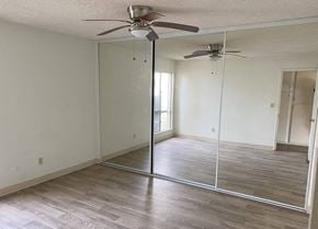 San Diego apartment for rent - A room with a ceiling fan and sliding glass doors.
