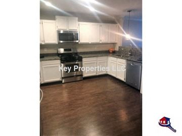 Knoxville house for rent - A kitchen with a stove top oven and a microwave built into the cabinetry.