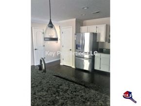 Knoxville house for rent - A kitchen with a black floor and a hanging light fixture.
