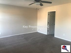Knoxville house for rent - A room with a ceiling fan and a door leading to another room.
