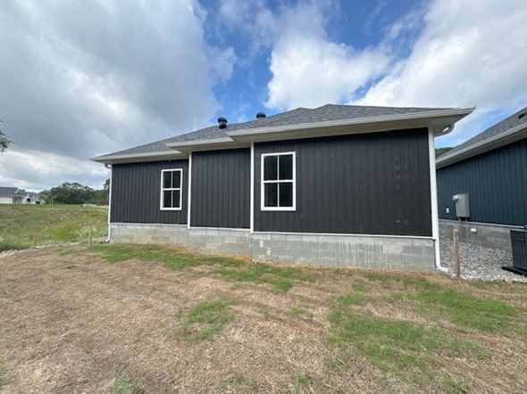 Little Rock house for rent - A grey building with a black roof and two windows.