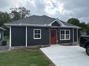 Little Rock house for rent - A black house with a red door and a grey roof.