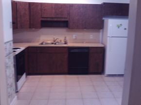 Crystal River house for rent - A kitchen with brown cabinets and a white fridge.