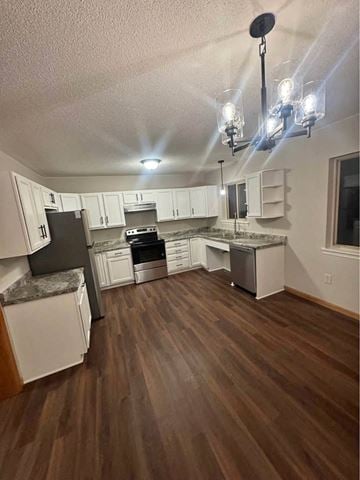 Rothschild house for rent - A kitchen with white cabinets and a black fridge.