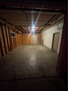 Rothschild house for rent - A room with a wooden wall and a door is shown.