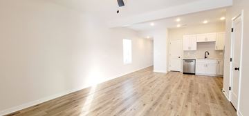 Warrensburg house for rent - A spacious kitchen with white cabinets and a wooden floor.