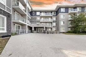 Calgary apartment for rent - A large, multi-story residential building with balconies and a driveway in front.