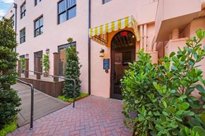 Miami apartment for rent - A building with a red brick walkway and a yellow awning.