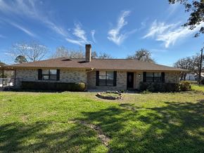 Victoria house for rent - A house with a brown roof and a chimney is surrounded by a grassy lawn.