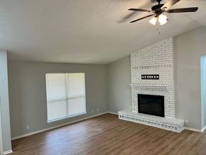 Victoria house for rent - A living room with a fireplace and a ceiling fan.