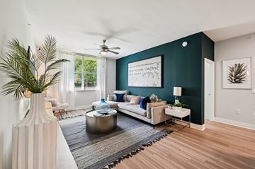 Pompano Beach apartment for rent - A living room with a white sofa, a coffee table, and a painting on the wall.