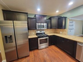 Lebanon house for rent - A kitchen with dark wood cabinets and stainless steel appliances.