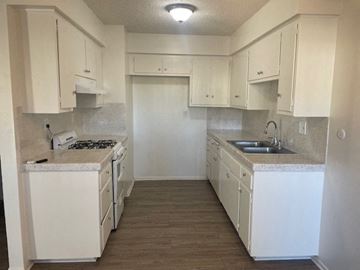 Santa Ana apartment for rent - A kitchen with white cabinets and a white counter top.