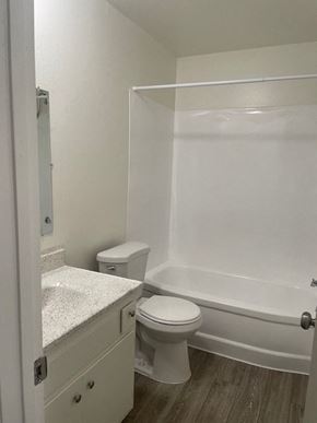 Santa Ana apartment for rent - A white bathroom with a toilet, sink, and bathtub.