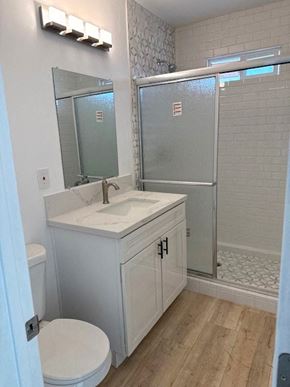 San Diego house for rent - A white bathroom with a toilet, sink, and shower.
