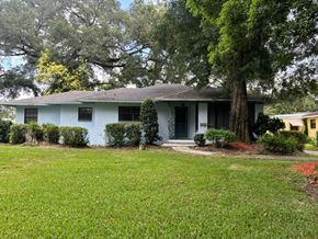Lakeland apartment for rent - A blue house with a green door and a tree in front.