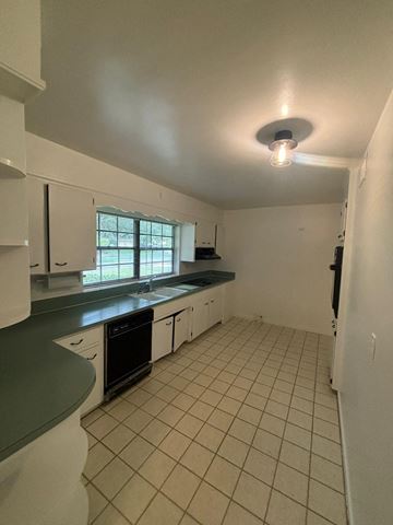 Lakeland apartment for rent - A kitchen with white cabinets and a black oven.