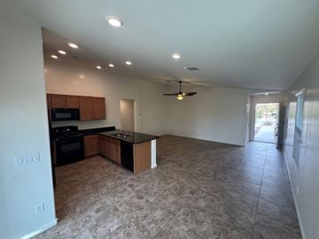 San Tan Valley house for rent - A kitchen with a black countertop and a fan on the ceiling.