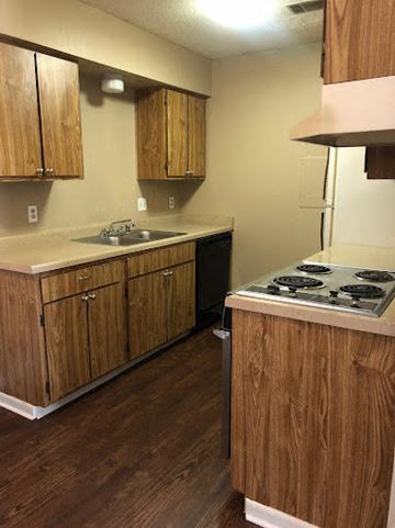 Little Rock apartment for rent - A kitchen with wooden cabinets and a stove top oven.