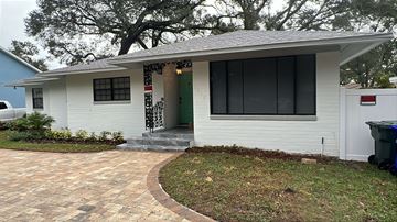 Lakeland apartment for rent - A white house with a green door and a red and white sign on the front door.
