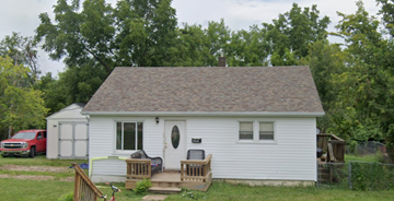 De Soto house for rent - A small white house with a brown roof and a red truck parked in front.
