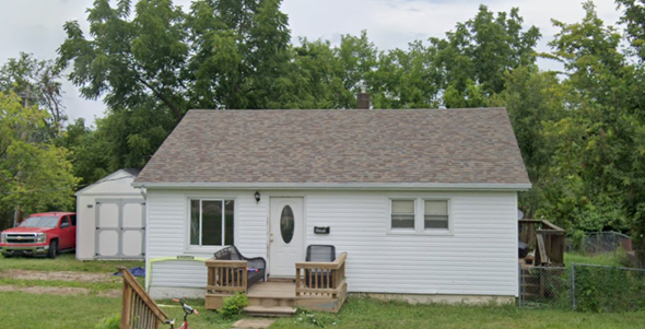 De Soto house for rent - A small white house with a brown roof and a red truck parked in front.
