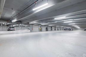Calgary apartment for rent - A spacious, empty parking garage with white walls and floors.