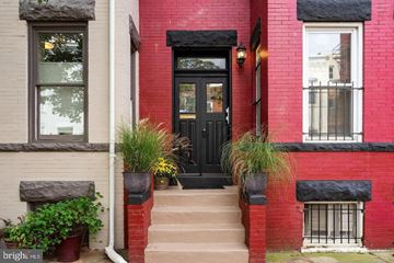 Washington apartment for rent - A red brick house with a black door and steps leading up to it.