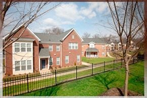 Raleigh townhouse for rent - A red brick house with a black fence in front.