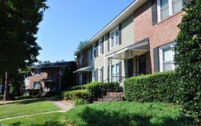 Raleigh apartment for rent - A residential building with a red brick facade and a green lawn in front.