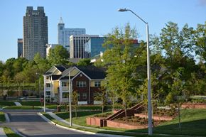 Raleigh apartment for rent - A street view of a residential area with apartment buildings and trees.