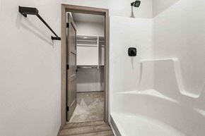 Sioux Falls house for rent - A white bathroom with a walk in shower and a doorway leading to a bedroom.