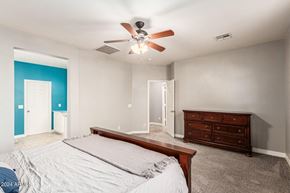 Buckeye house for rent - A bedroom with a bed, dresser, and ceiling fan.