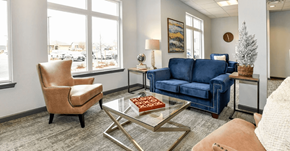 Greeley apartment for rent - A living room with a blue couch, a chair, and a coffee table.