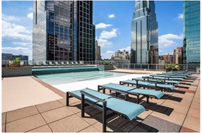 Kansas City apartment for rent - A pool with sun loungers on a terrace with buildings in the background.