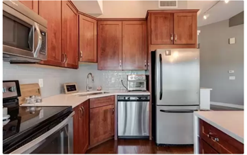 Kansas City apartment for rent - A kitchen with wooden cabinets and stainless steel appliances.