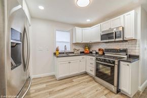 Gary house for rent - A kitchen with white cabinets and stainless steel appliances.