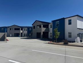 Rio Rancho apartment for rent - A parking lot in front of a building with blue and white exterior.