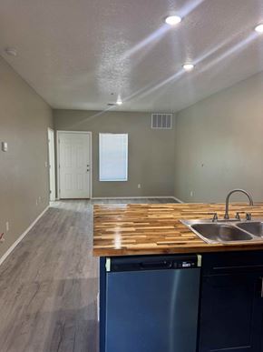 Rio Rancho apartment for rent - A kitchen with a wooden counter top and a dishwasher.
