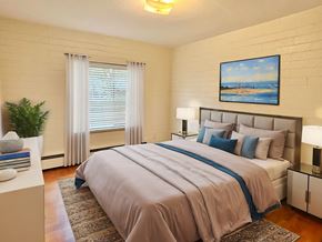 Lakewood apartment for rent - A bedroom with a large bed and a painting on the wall.