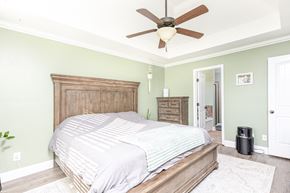 Clarksville house for rent - A bedroom with a bed, dresser, and ceiling fan.