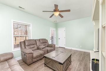 Clarksville house for rent - A living room with a brown leather couch and a brown coffee table.