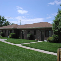 Pilger apartment for rent - A building with a brown roof and a green lawn in front.