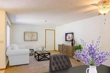 White Bear Lake apartment for rent - A living room with a white couch, a black coffee table, and a painting on the wall.