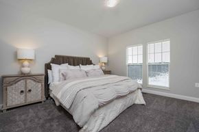 Lewis Center apartment for rent - A bedroom with a large bed and a nightstand with a lamp.